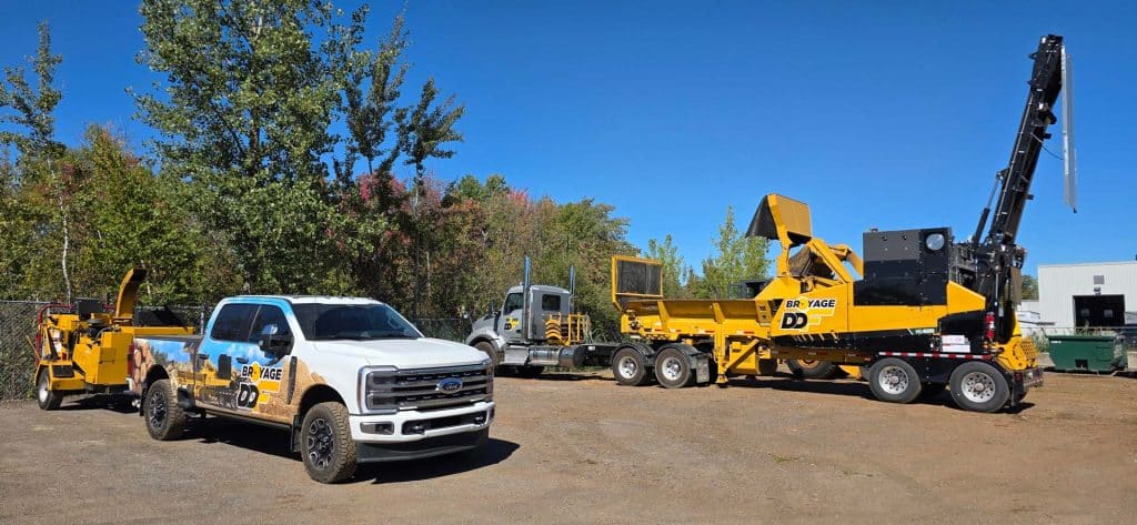 Camion, broyeur industriel Vermeer HG4000 et déchiqueteuse mobile aux couleurs de Broyage DDF stationnés sur un site forestier au Québec